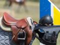 20.07.2018, Thüringen, Crawinkel: Ein Sattel, ein Helm und Schutzkleidung liegen beim Landeschampionat der Nachwuchspferde auf einem Zaun. Vier bis sechs Jahre alte Sportpferde von Thüringer Züchtern zeigen am Wochenende bei einem Reitturnier ihr Können. (