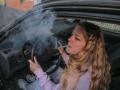 junge frau kifft am autosteuer junge frau kifft am autosteuer *** young woman smokes pot at car steering wheel young wom