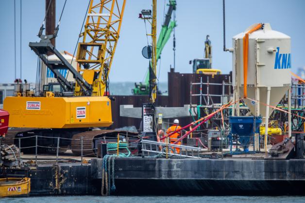 Mit Kranen werden Betonkonstruktionen für den neuen Inselhafen vor dem Ostseestrand montiert. Mit Kranen werden Betonkonstruktionen für den neuen Inselhafen vor dem Ostseestrand montiert.