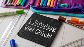 8 August 2023: School pencil case with crayons and a blackboard with inscription: 1st day of school Good luck. Congratul