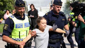 TOPSHOT - Climate activist Greta Thunberg is carried away by police officers after she took part in a new climate action in Oljehamnen in Malmo, Sweden on July 24, 2023, shortly after the city&apos;s district court convicted and sentenced her to a fine for disobeying police at a rally last month during a climate action in the Norra hamnen neighbourhood of Malmo. Thunberg was fined on Monday for disobeying police at a rally last month, but said she acted out of necessity due to the climate crisis. (Photo by Andreas HILLERGREN / TT News Agency / AFP) / Sweden OUT