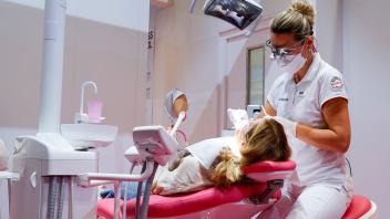 Symbolbild fuer Zahnarzt bei Zahnbehandlung Symbolfoto fuer Zahnaerztin bei Behandlung eines Patienten auf dem Zahnarzts