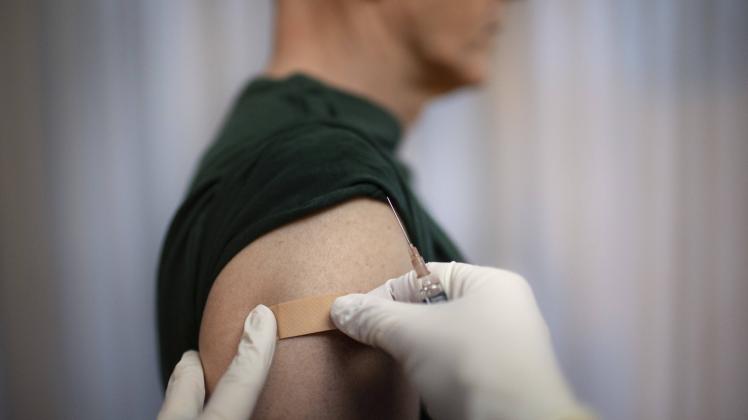 Thema: Impfung. Arzt klebt ein Pflaster auf die Einstichstelle Bonn Deutschland *** Topic Vaccination Doctor sticks a pl