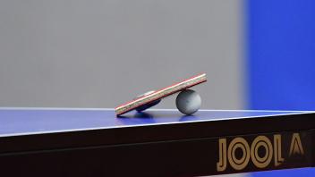 Ein Tischtennisschlaeger mit Ball liegt auf einer Tischtennisplatte, Themenfoto: Tischtennis, Detailaufnahme, 25.04.2023