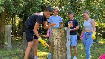 Jugendliche aus Serbien reinigen Grabsteine auf dem jüdischen Friedhof in Osnabrück