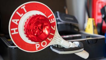 Symbolbild Winkerkelle Halt Polizei fuer die Verkehrskontrolle Symbolfoto Winkerkelle Halt Polizei Ausruestung der Poliz