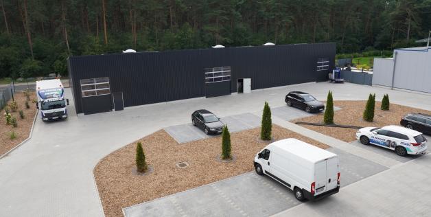 Hinten ist die neue Lagerhalle für Reifen zu sehen, vorne die Parkplätze im Innenhof.