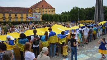 Ukrainer aus Osnabrück und Münster verbinden ihre Flagen vor der Stadthalle in Osnabrück