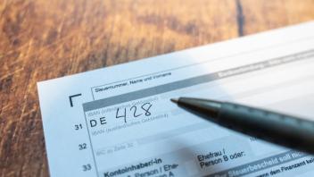 Langweid, Bavaria, Germany - 23 June 2023: A man fills out a form to submit a tax return to the tax office. Main form fo