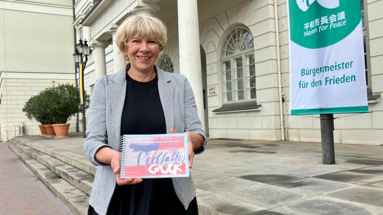 Eine Frau hält ein Rezeptbuch in der Hand
