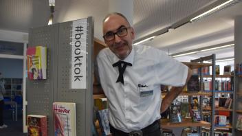 Büchereileiter Michael Harbeck vor dem BookTok-Regal. 