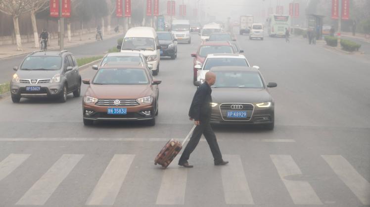 BEIJING CHINA APRIL 02 A citizen walks on the road amid heavy smog on April 2 2018 in Beijing