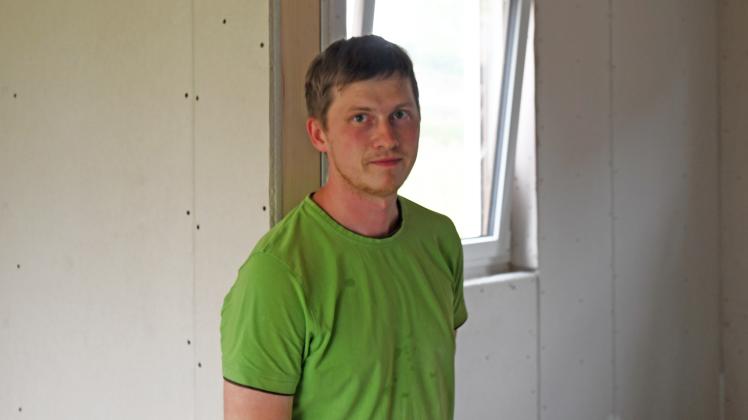 Stanislaw Schwarz in einem grünen T-Shirt im Rohbau seines Hauses