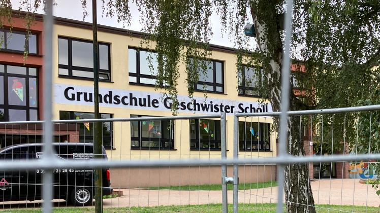 Schriftzug der Grundschule Geschwister Scholl in Perleberg hinter Bauzaun zu erkennen. An der Schule wird ein Erweiterungsanbau vorgenommen.