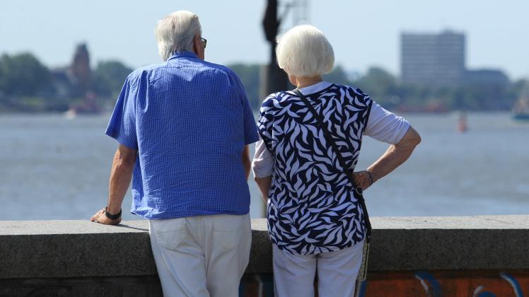 Ein älteres Paar steht an einer Mauer und schaut auf den Elbstrand. Symbolbild/Symbolfoto Liebe. Altona Hamburg *** An e