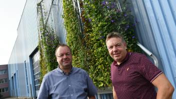 Michael (links) und Thomas Wurst haben auf ihrem Firmengelände das erste Gerüst für die Fassadenbegrünung angebracht. Und obwohl sie erst im Mai gepflanzt haben, sind die Pflanzen schon weit nach oben geklettert.