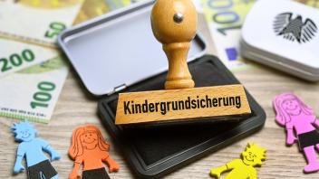 FOTOMONTAGE, Stempel mit Aufschrift Kindergrundsicherung *** PHOTOMONTAGE, stamp with inscription child basic security