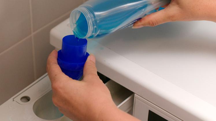 30.08.2020, Haushalt: Eine Hausfrau schüttet Flüssigwaschmittel in das Waschpulverfach ihrer Waschmaschine. 30.08.2020,