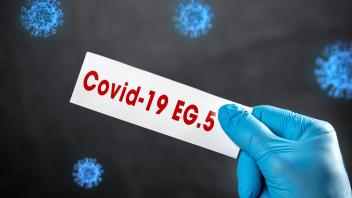 Bavaria, Germany - 15 August 2023: Corona Virus Covid-19 Mutation ERIS EG.5 Variant. Hand with protective glove holding 