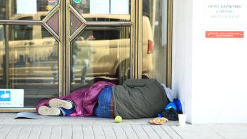 Ein Obdachloser liegt vor einem wegen des Lockdowns geschlossenem Hotels in Hamburg-St.-Georg. St. Georg Hamburg *** A h