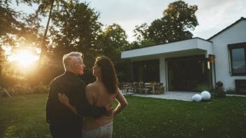 Couple looking at each other standing in garden at sunset model released property released, GUSF07072