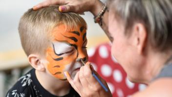 Kinderschmink-Künstlerin Nadja verwandelt Vincent (4 Jahre) in einen Tiger...Buntes Treiben beim Zoofest in Rostock:jede Menge Attraktionen gab es am Sonntag auf dem Veranstaltungsplatzt und in dessen Umgebung zu bewundern.Foto: Georg Scharnweber