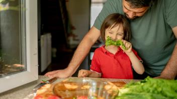 Son eating lettuce with father at home model released, Symbolfoto property released, ANAF01645