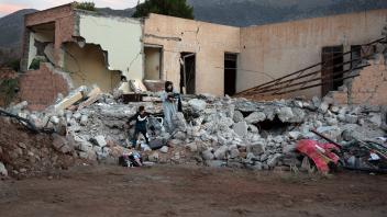 September 11, 2023, Idni, Morocco: A woman and her son remove their belongings from a house that was completely destroye