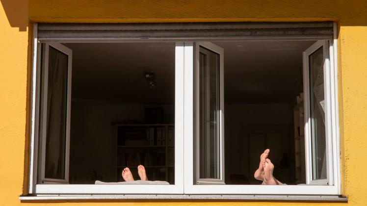 Nackte Füße am offenen Fenster