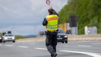 Bild: Polizist zieht Fahrzeuge zum kontrollieren aus dem Verkehr Würzburg, A3, Parkplatz Sandgraben Süd, 10.05.2023, Bla