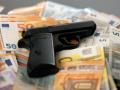 Ein Pistole auf geraubten Banknoten liegend. (Symbolfoto, Themefoto) *** A pistol lying on robbed banknotes symbol photo