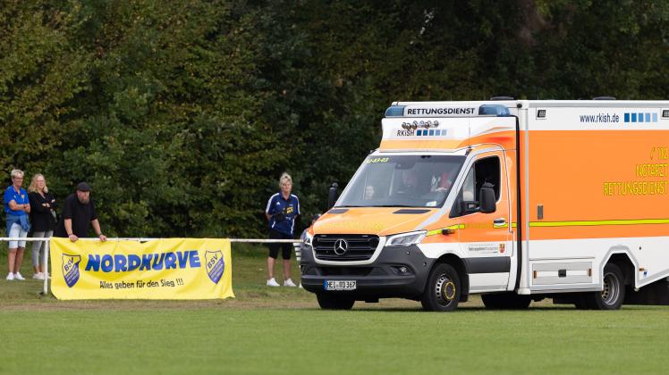 Verteidiger Timo Bahl vom Barkelsbyer SV wird vor der „Nordkurve“ im Stadion an der Au mit dem Rettungswagen abtransportiert. Der 24-Jährige verletzte sich im Heimspiel gegen den TSV Büsum.