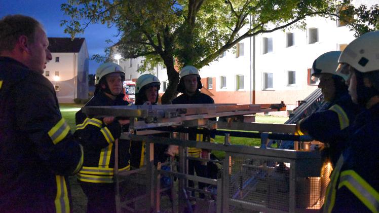 Mathias Leisten (l.) erklärt, worauf es bei der Lagerung eines Menschen im Korb der Drehleiter ankommt.