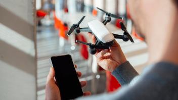 Businessman with mobile phone and drone at office model released, Symbolfoto property released, JOSEF18135