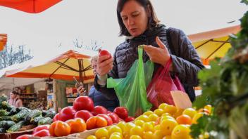 SOCHI, RUSSIA   MARCH 25, 2022: A customer chooses tomatoes at a food fair in the Matsesta District. Dmitry Feoktistov/T