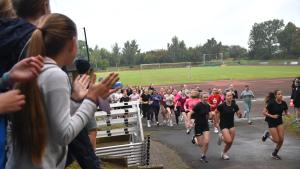 Beim Voßlauf ist niemand allein: Die Jüngeren feuern die Läuferinnen an, die sich aus dem Stadion auf die Laufstrecke machen.