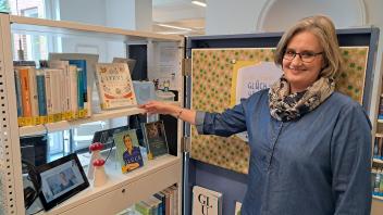 Anett Petersen, Mitarbeiterin der Stadtbücherei Niebüll, zeigt den Themenraum Glück.