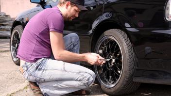 Reifenwechsel, junger Mann wechselt von Winterreifen auf Sommerreifen, Serienbild 9/9 tire change, young man changes win