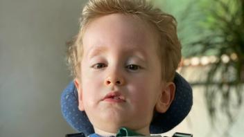 Der dreijährige Matteo sitzt in einem Spezialstuhl