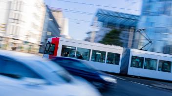Straßenbahn fährt hinter Autos entlang.