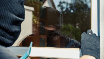 Augsburg, Bavaria, Germany - August 7, 2023: Symbol image burglary in the apartment, apartment burglary. Masked burglar 