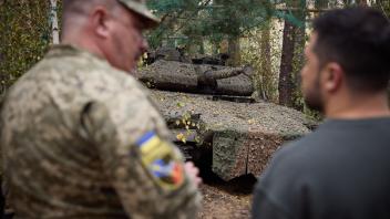 This handout photograph taken and released by the Ukrainian Presidential Press Service on October 3, 2023 shows the Ukrainian President Volodymyr Zelensky (R) talking to a serviceman in front of a tank as he visits the location of the 103rd Separate Brigade of the Territorial Defense Forces of the Armed Forces of Ukraine, the 68th Separate Yeger Brigade, and the 25th Separate Sicheslav Airborne Brigade, which are performing combat missions in the Kupyansk-Lyman area, in the Kharkiv region. (Photo by Handout / UKRAINIAN PRESIDENTIAL PRESS SERVICE / AFP) / RESTRICTED TO EDITORIAL USE - MANDATORY CREDIT "AFP PHOTO / UKRAINIAN PRESIDENTIAL PRESS SERVICE" - NO MARKETING NO ADVERTISING CAMPAIGNS - DISTRIBUTED AS A SERVICE TO CLIENTS