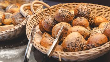 16 July 2023: Several buns laid out with tongs in a basket at a breakfast buffet *** Mehrere Brötchen, die mit einer Zan