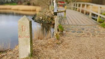 Der Markierungsstein auf dänischer Seite des Grenzübergangs Schusterkate ist neu befestigt worden. Das Hochwasser Ende vergangenen Jahres hatte den Stein durch Unterspülen in eine bedrohliche Lage gebracht.