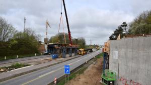 Mit einem 500-Tonnen-Mobilkran wird ein Stahlträger über der A7 Richtung Hamburg eingehoben.