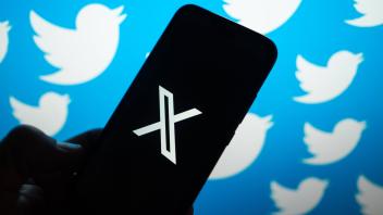 Illustration in Poland. In this photo illustration, the X logo seen displayed on a smartphone with Twitter logos in the 