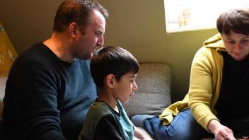 Tobias Wolff zusammen mit seinem Pflegesohn Mika beim Spielen mit der Familie auf der Couch. Mika sucht immer wieder die Nähe zu seinen Eltern.