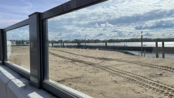 Blick durchs Fenster der neuen Flutschutzmauer auf die Baustelle an der Ostmole im Schulauer Hafen in Wedel.