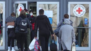 Niedersachsen, Hannover: Flüchtlinge aus der Ukraine gehen in die Messehalle 27 auf dem Messegelände. Nachdem in der Me