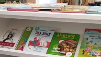 Bücher und Spiele, die die Lesekompetenz von Kindern fördern, liegen in den Regalen aus und können von allen Schülern ausgeliehen werden.